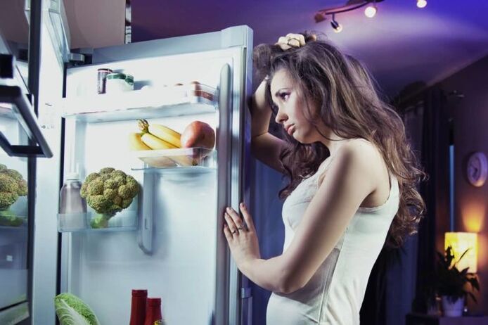Mädchen am Kühlschrank, während sie ihrer Lieblingsdiät folgt